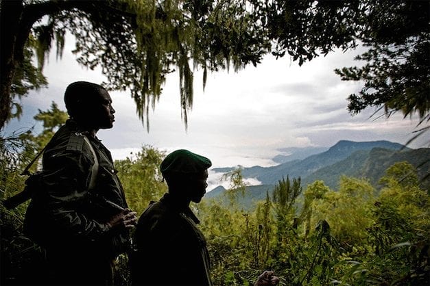 Two Rangers facing the the mountainous landscape of the Park