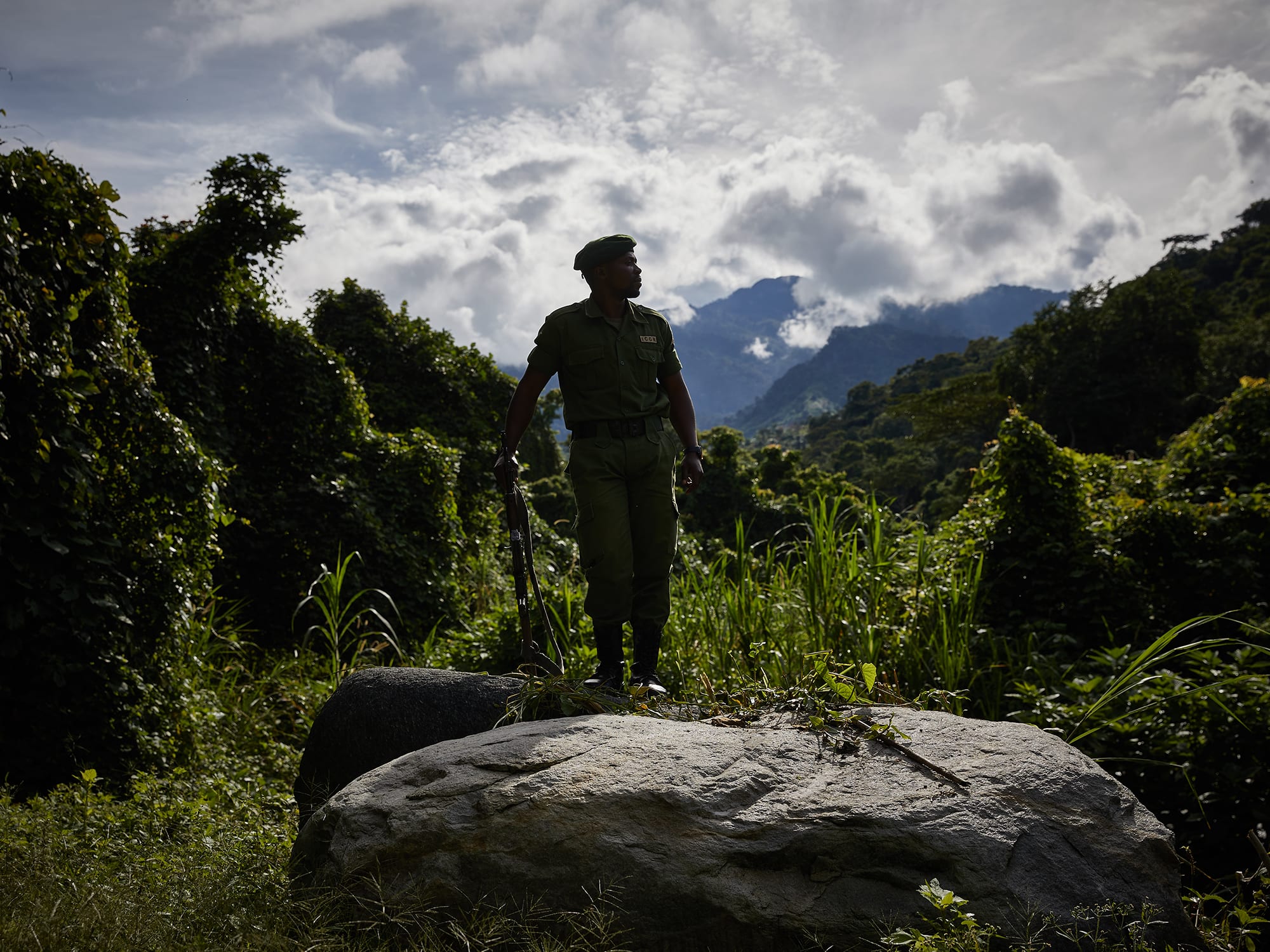 A Ranger of the Park posing with the tropical rainforest in the background